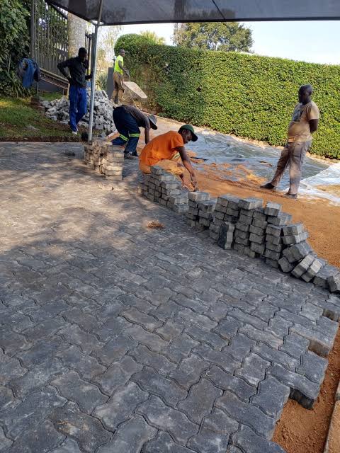 Crew laying paving blocks on a driveway